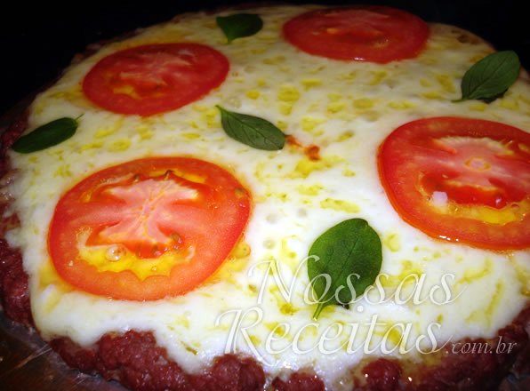 Receita de pizza preparada com carne moída, muçarela e tomate